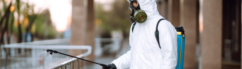 man-in-protective-suit-and-mask-sprays